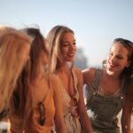 Four women enjoying a sunny day outdoors, expressing friendship and joy.